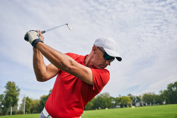 Golfer wearing warm-tinted sunglasses lining up a shot on a green